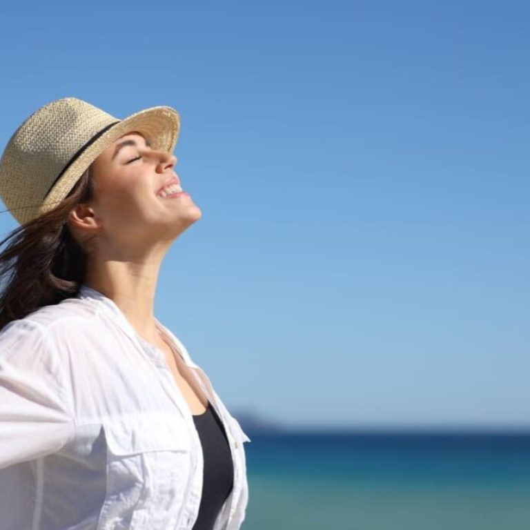 Woman enjoying sunlight at the beach.