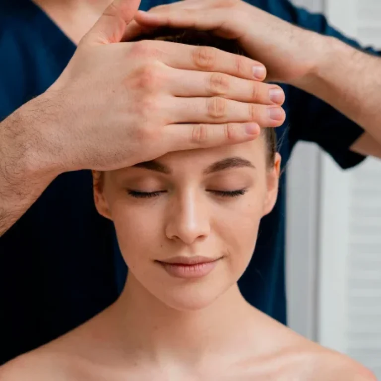 Person receiving head massage with eyes closed.